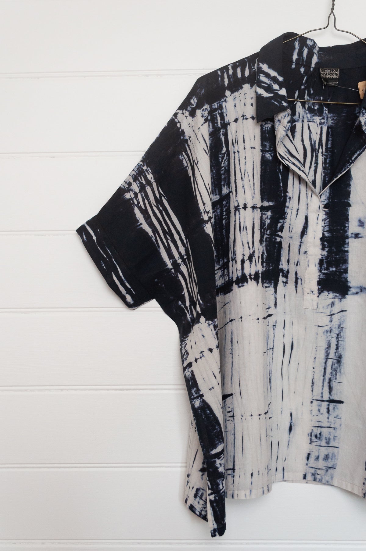 Neeru Kumar short-sleeve collared shirt with a black and white shibori tie-dye pattern.