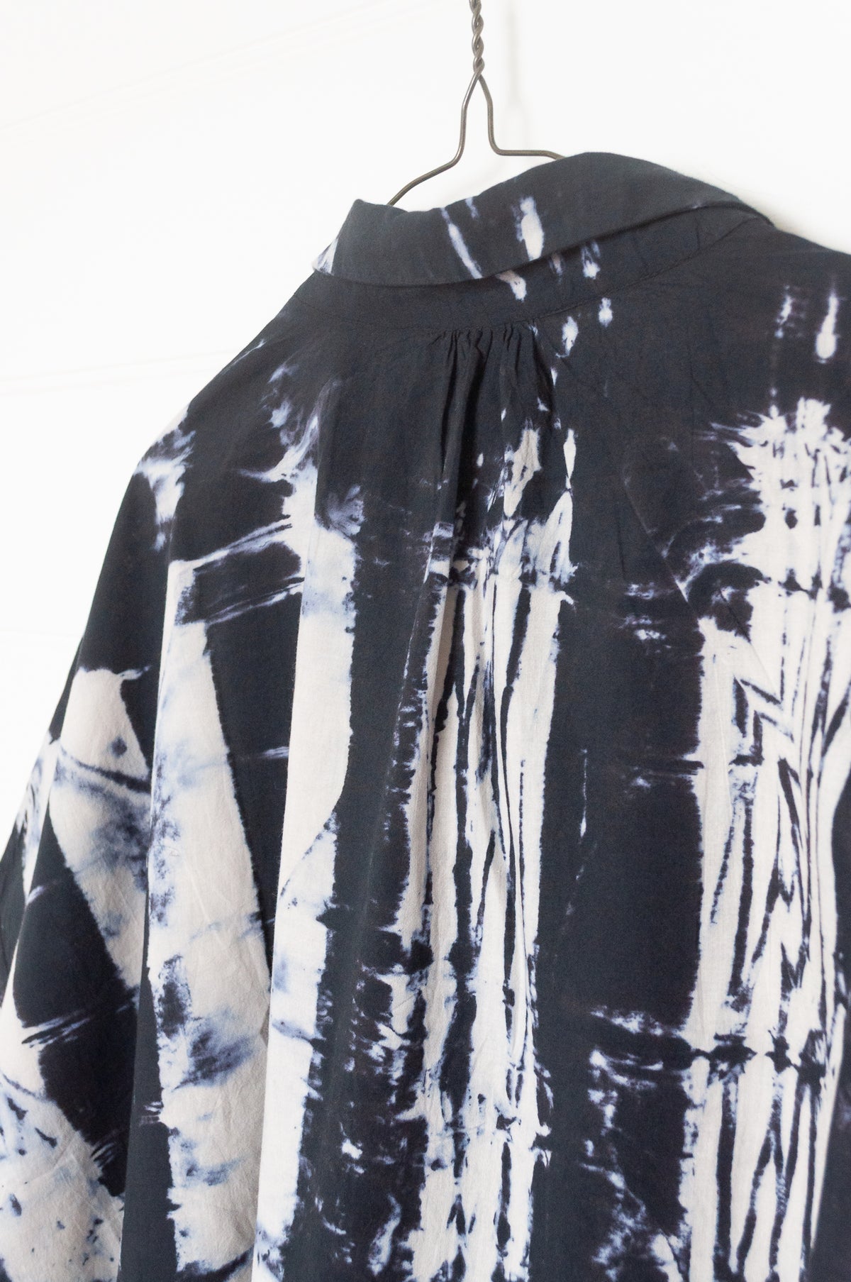 Neeru Kumar short-sleeve collared shirt with a black and white shibori tie-dye pattern.