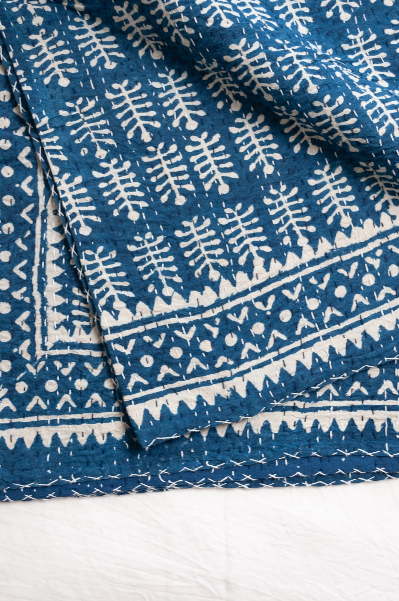 Indigo blue and white pure cotton kantha stitch bed quilt with fern design.