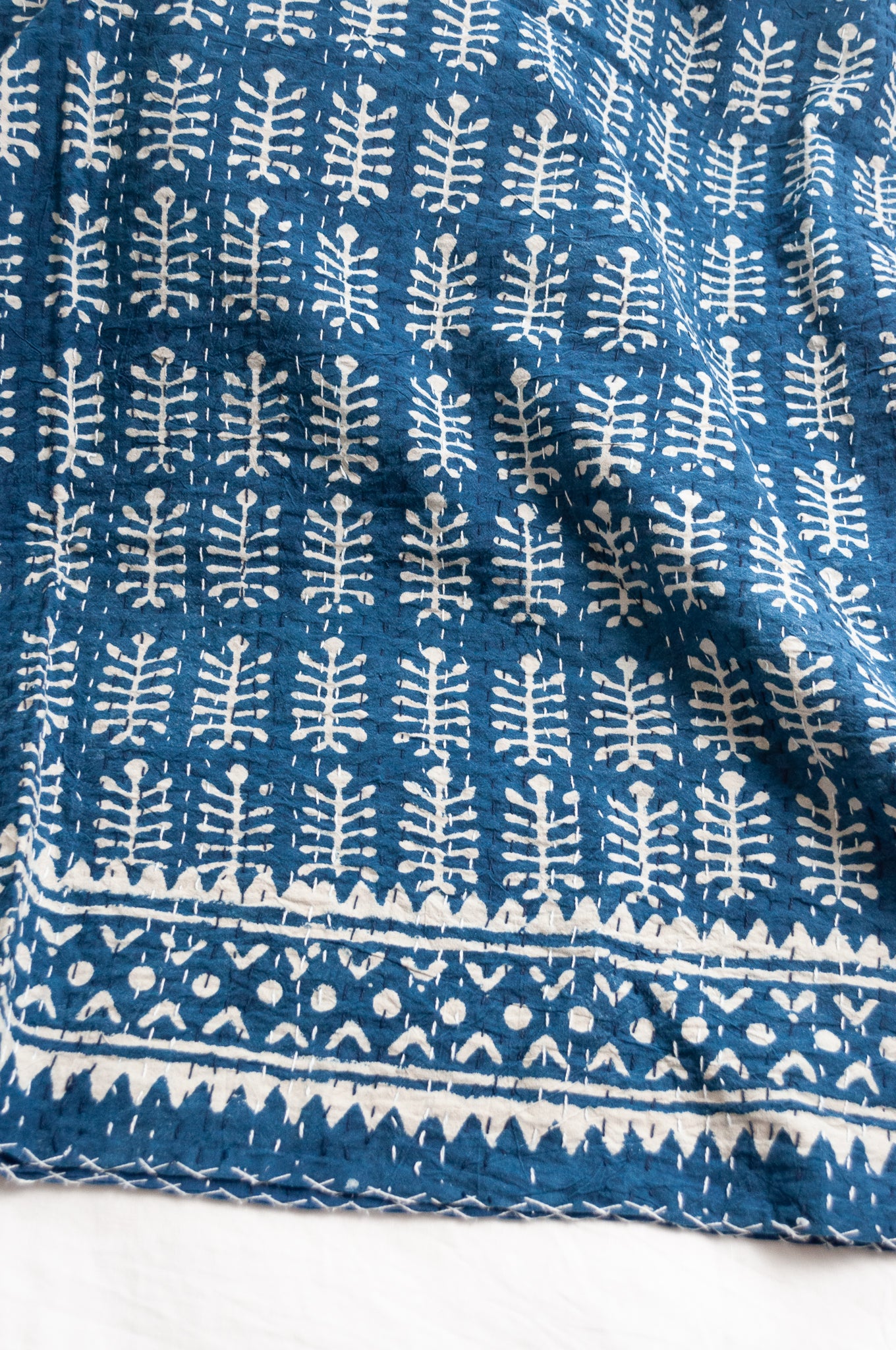 Indigo blue and white pure cotton kantha stitch bed quilt with fern design.