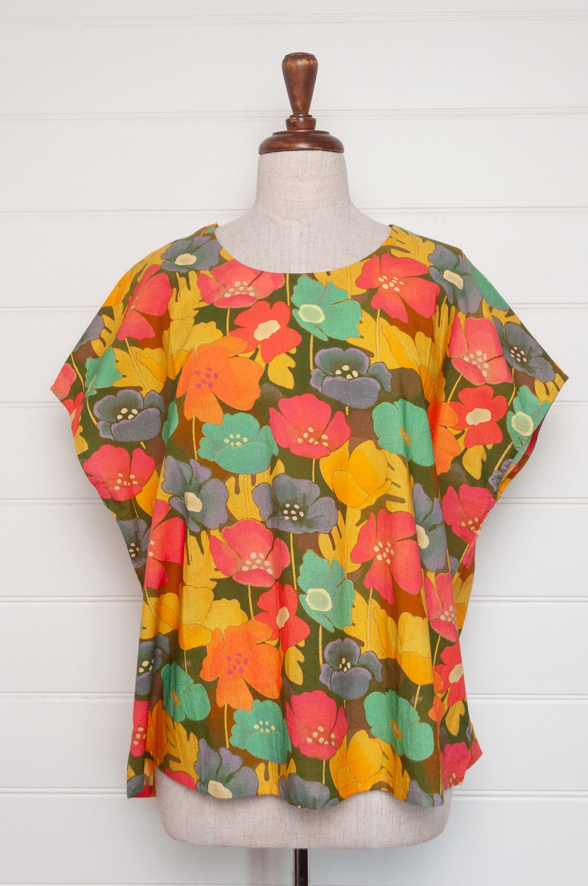 Neeru Kumar round neck cap sleeve top with a colorful floral pattern.
