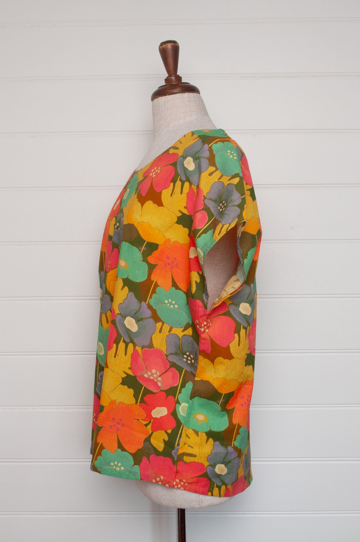 Neeru Kumar round neck cap sleeve top with a colorful floral pattern.