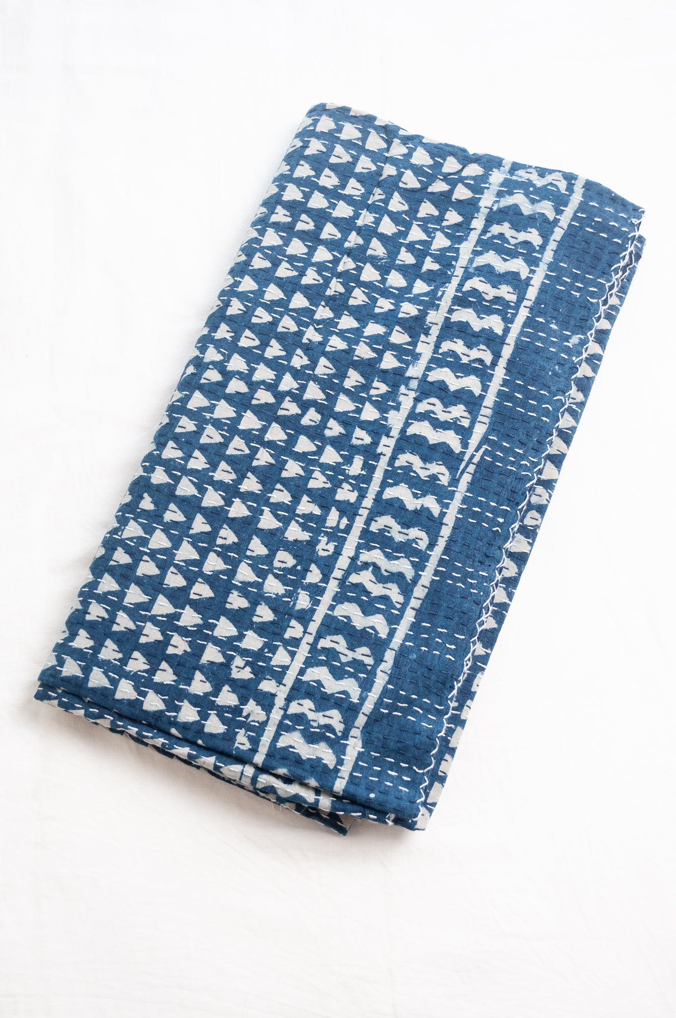 Indigo blue and white pure cotton kantha stitch bed quilt with triangle design.