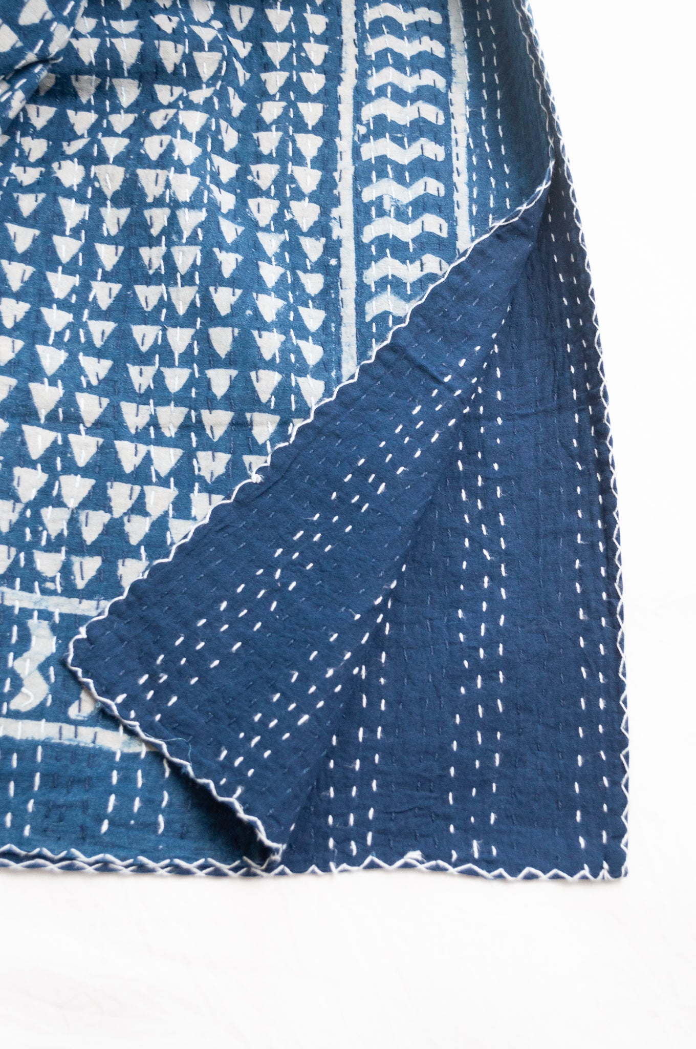 Indigo blue and white pure cotton kantha stitch bed quilt with triangle design.
