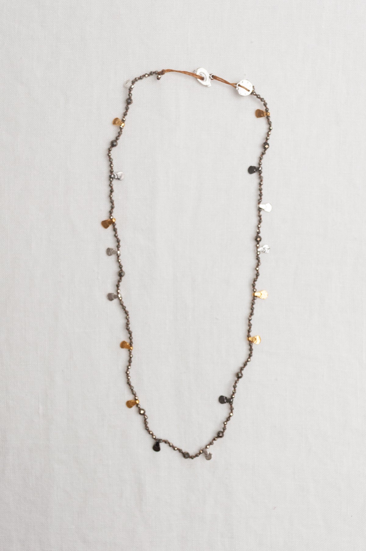 Mary Gaitani handmade pyrite necklace with silver and gold charms.