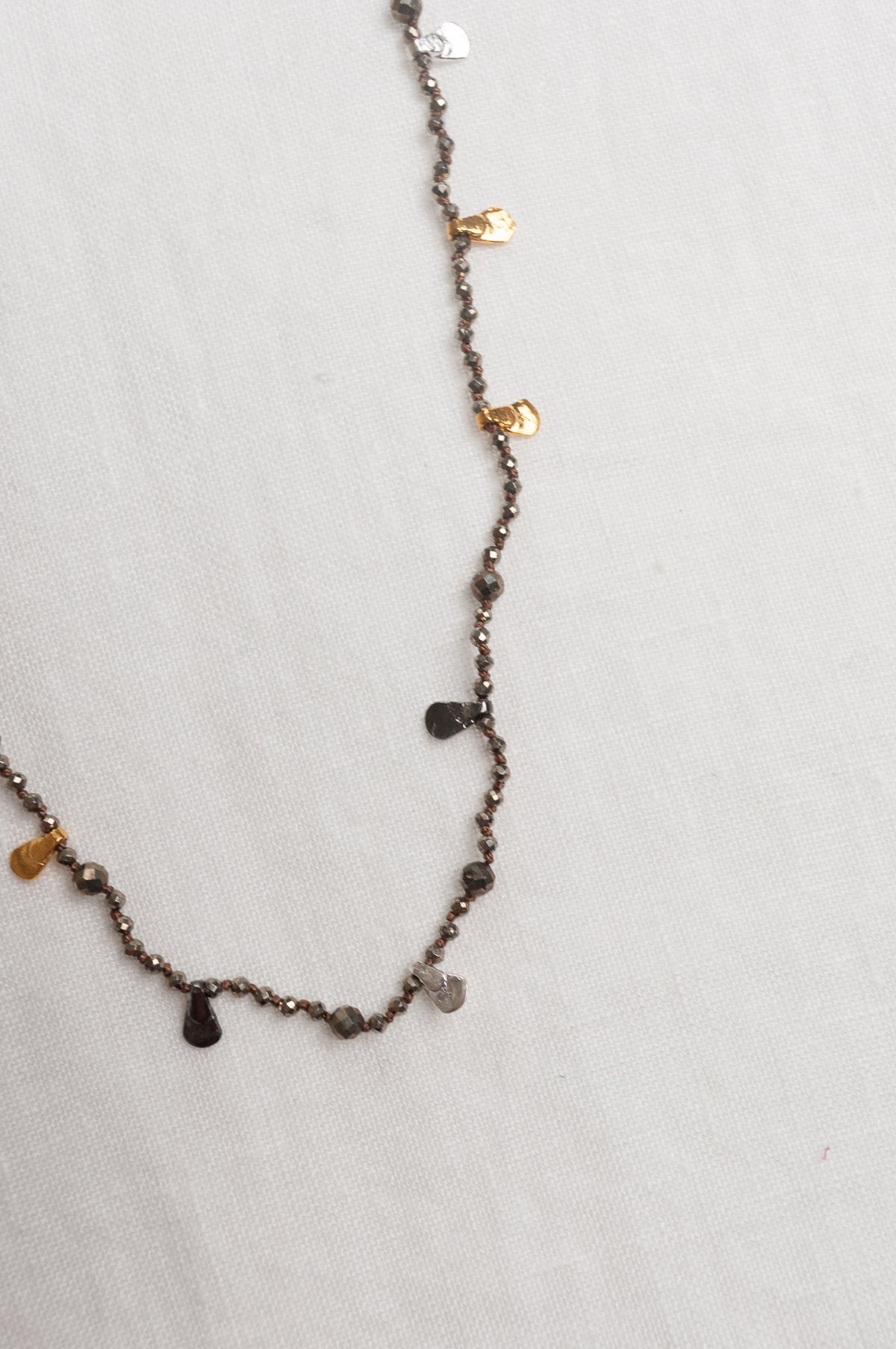 Mary Gaitani handmade pyrite necklace with silver and gold charms.