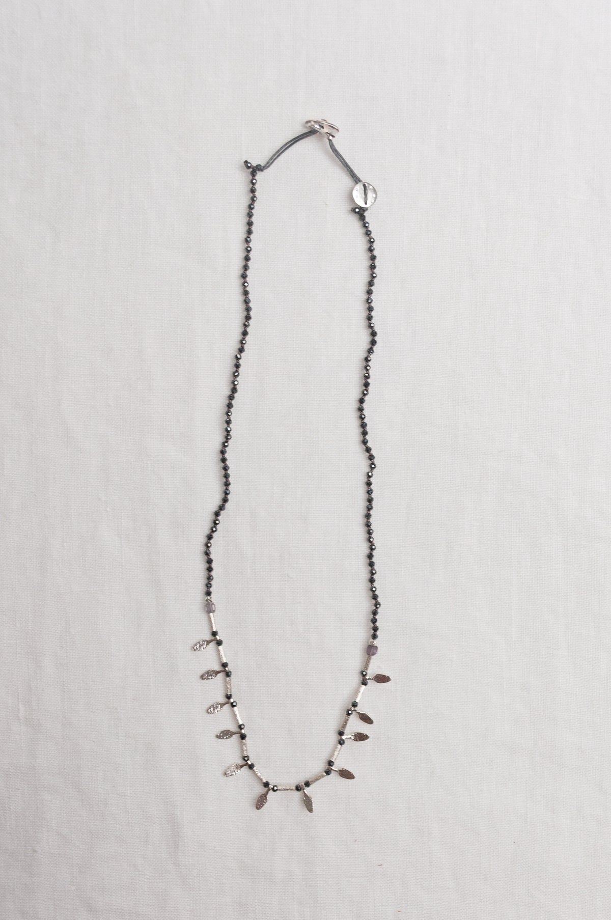Mary Gaitani handmade grey spinels necklace with silver charms.