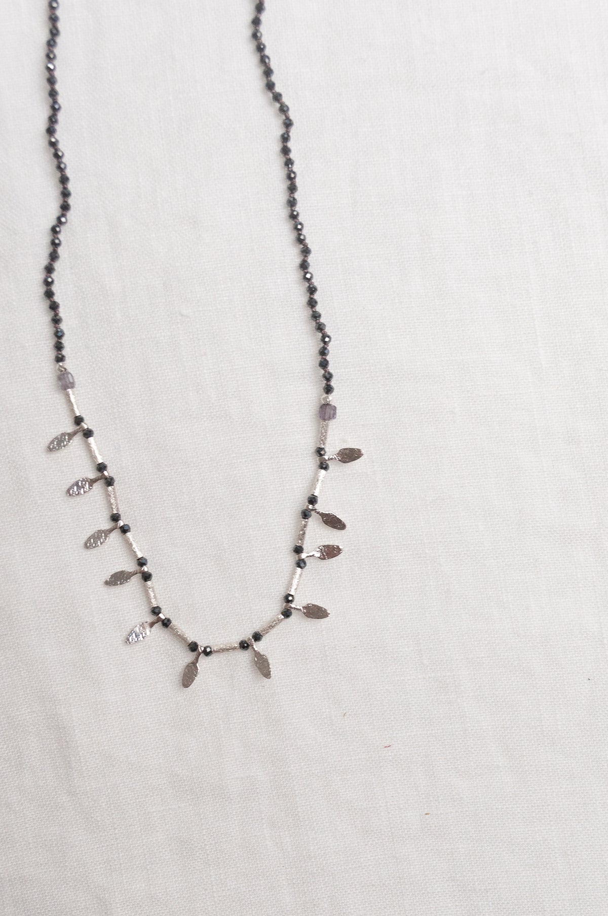 Mary Gaitani handmade grey spinels necklace with silver charms.