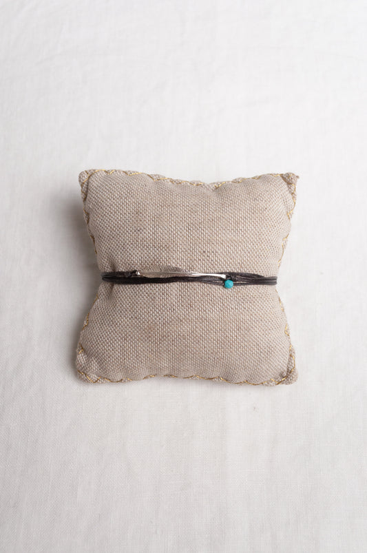Mary Gaitani hand tooled silver feather bracelet on charcoal waxed cord with turquoise bead.