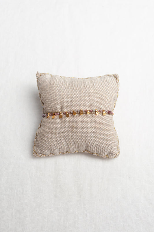 Mary Gaitani hand tooled gold charms on taupe waxed plaited cord with semi-precious stones.