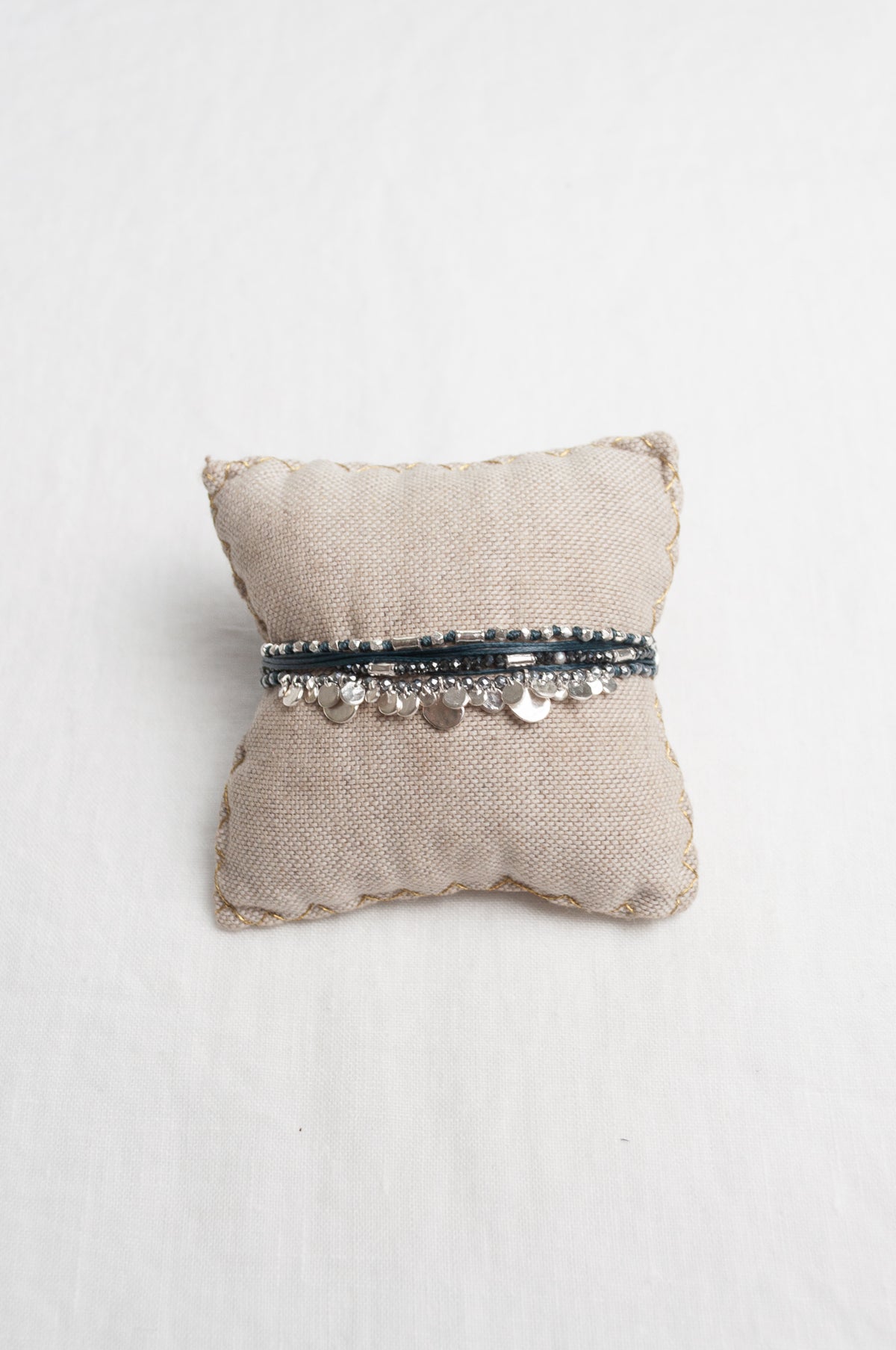 Mary Gaitani hand tooled silver charms on navy cord with semi-precious stones.