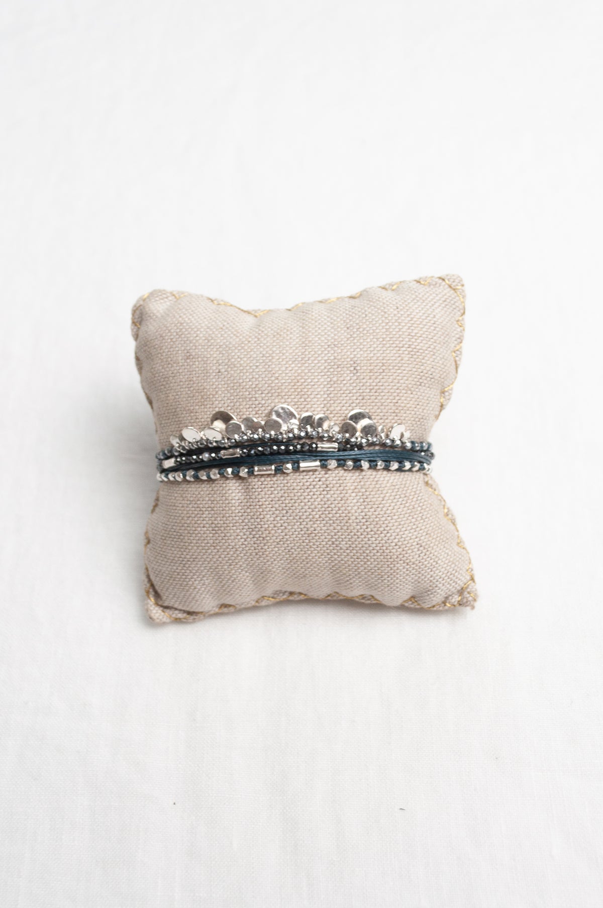 Mary Gaitani hand tooled silver charms on navy cord with semi-precious stones.