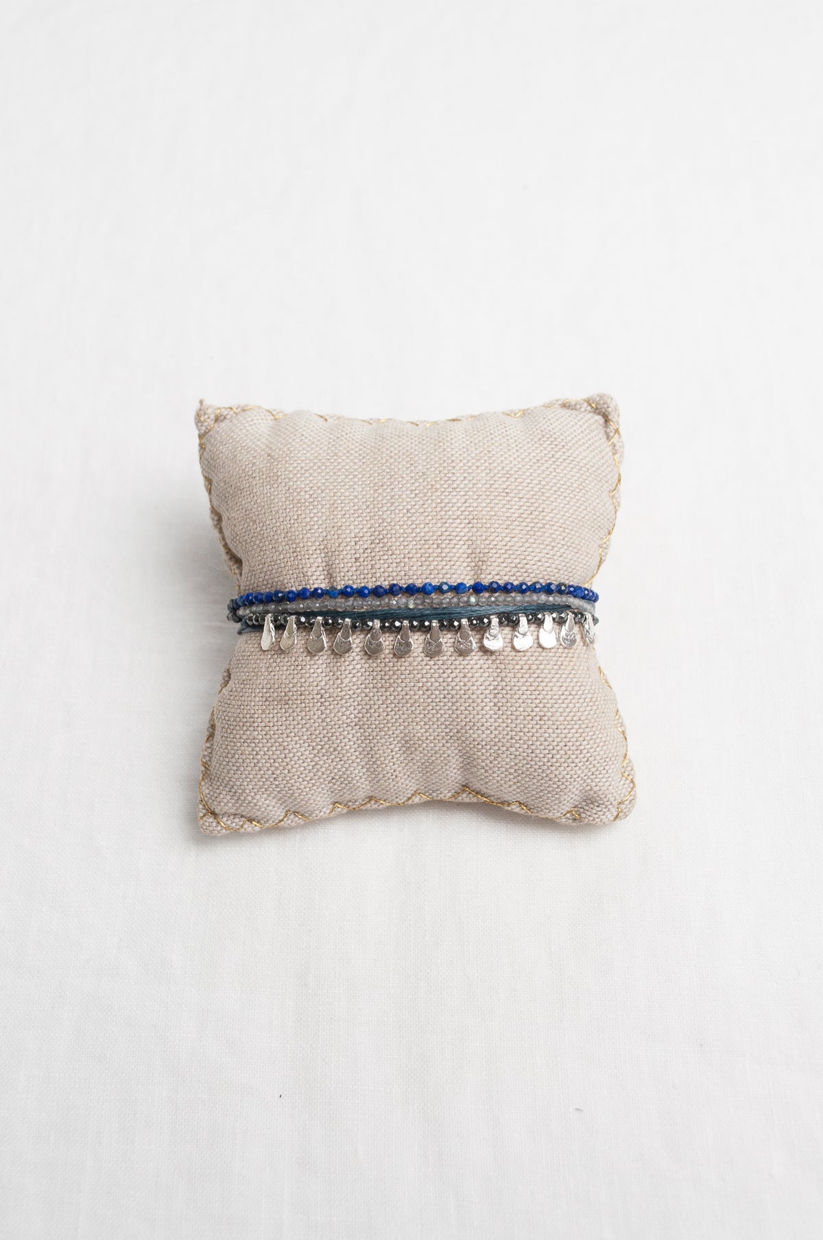 Mary Gaitani hand tooled silver teardrop charms on navy cords with semi-precious stones.