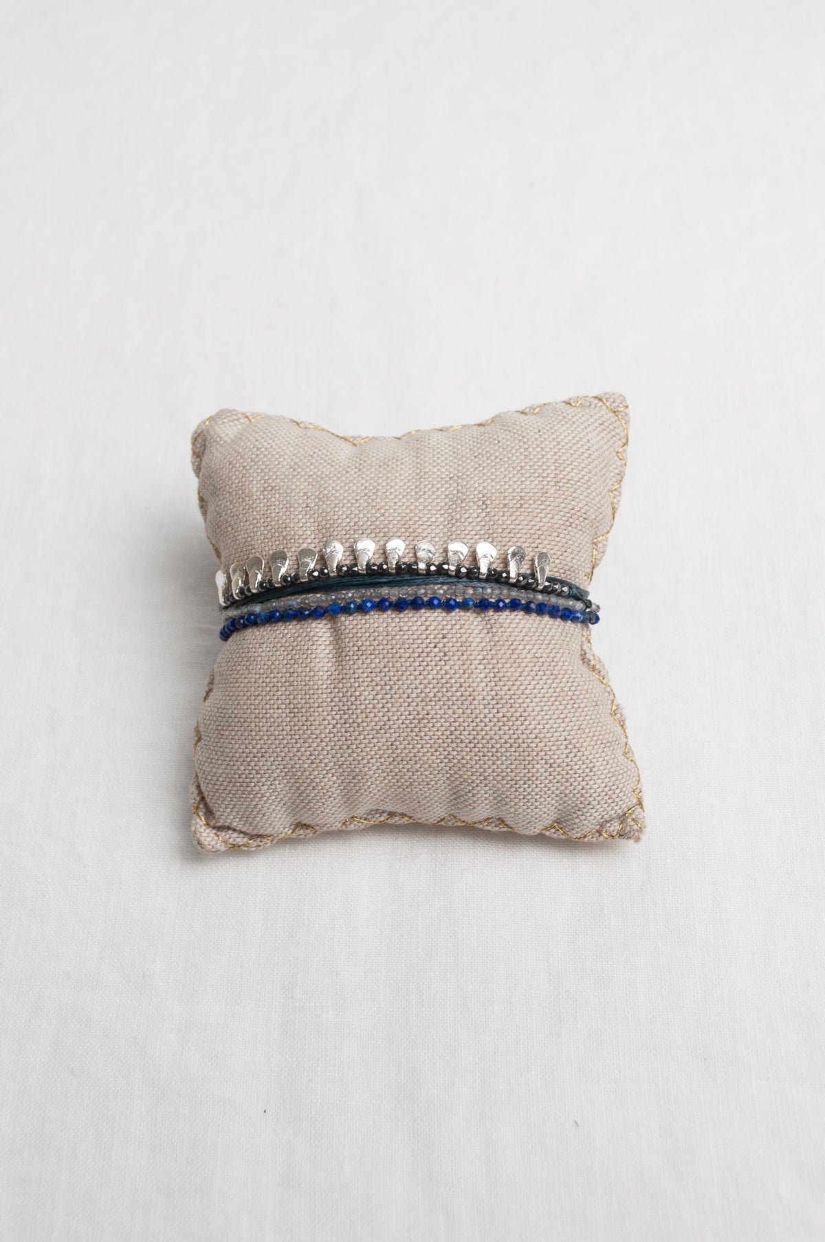Mary Gaitani hand tooled silver teardrop charms on navy cords with semi-precious stones.