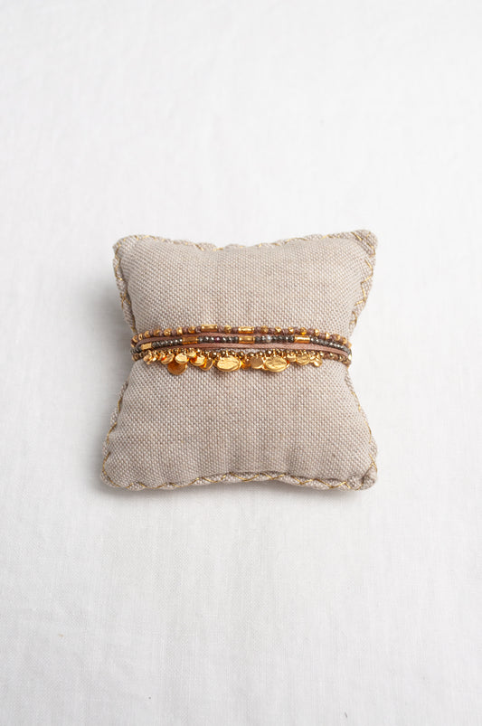 Mary Gaitani hand tooled gold charms on stranded taupe cords with semi-precious stones.