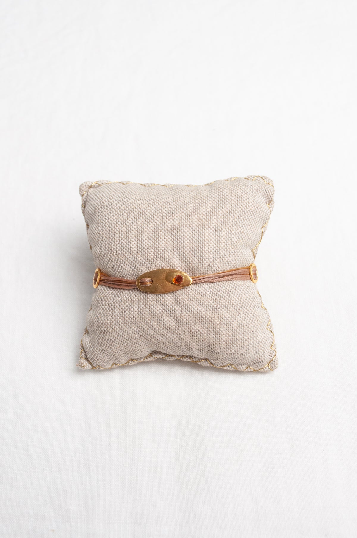 Mary Gaitani hand tooled gold charms on stranded taupe cords with semi-precious stones.