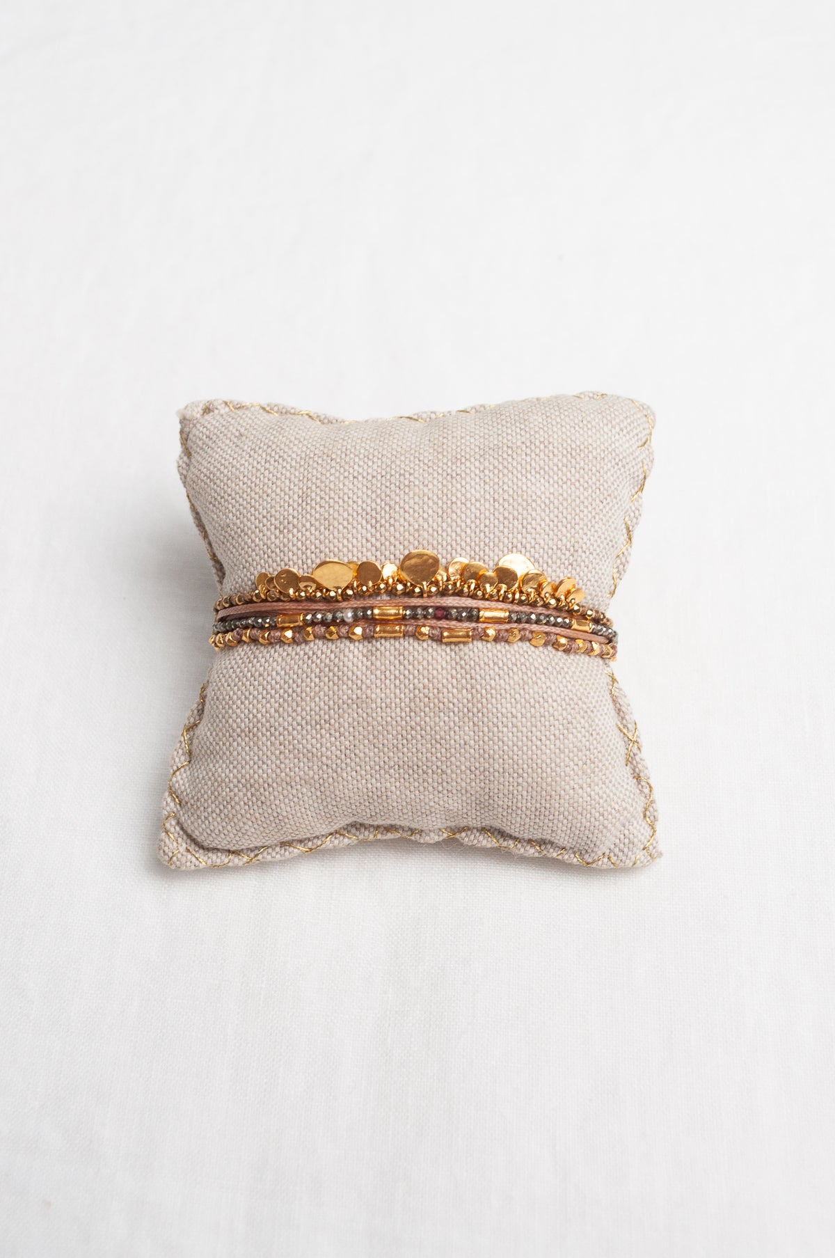 Mary Gaitani hand tooled gold charms on stranded taupe cords with semi-precious stones.