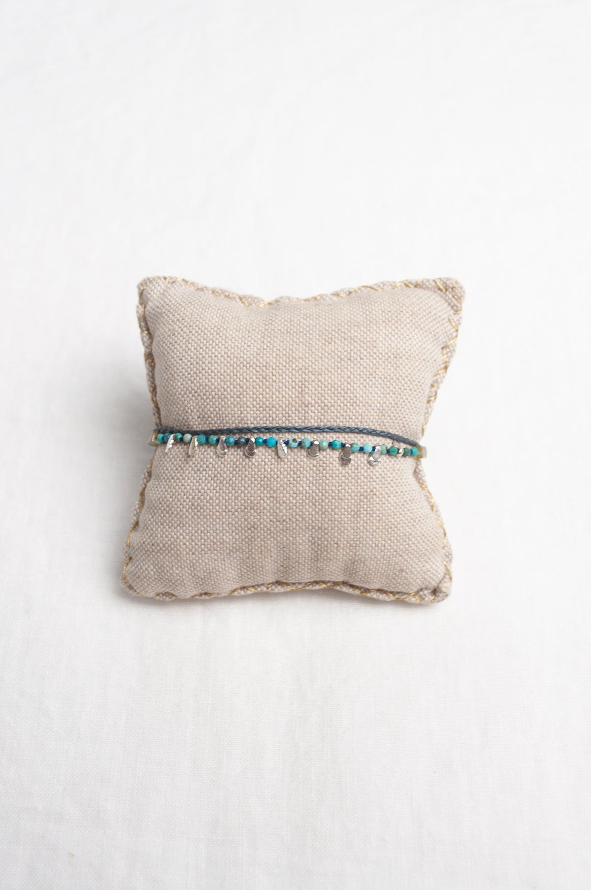 Mary Gaitani hand tooled silver charms on stranded cords with turquoise beads.