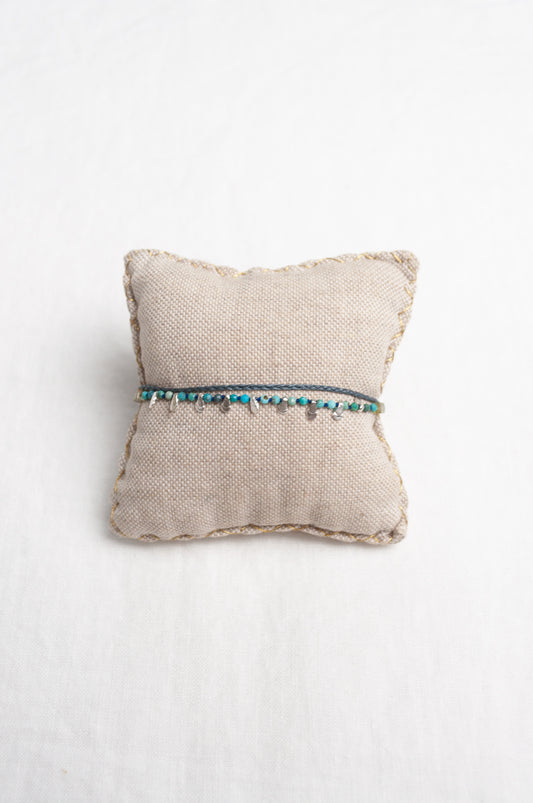 Mary Gaitani hand tooled silver charms on stranded cords with turquoise beads.