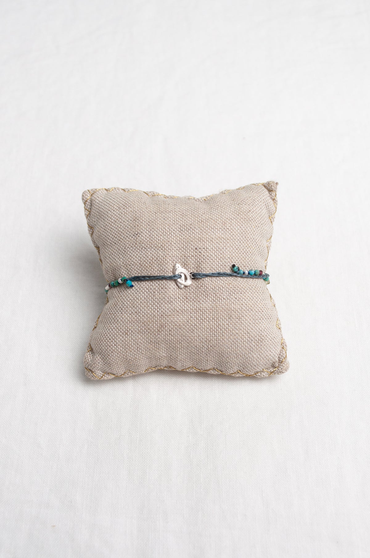 Mary Gaitani hand tooled silver charms on stranded cords with turquoise beads.