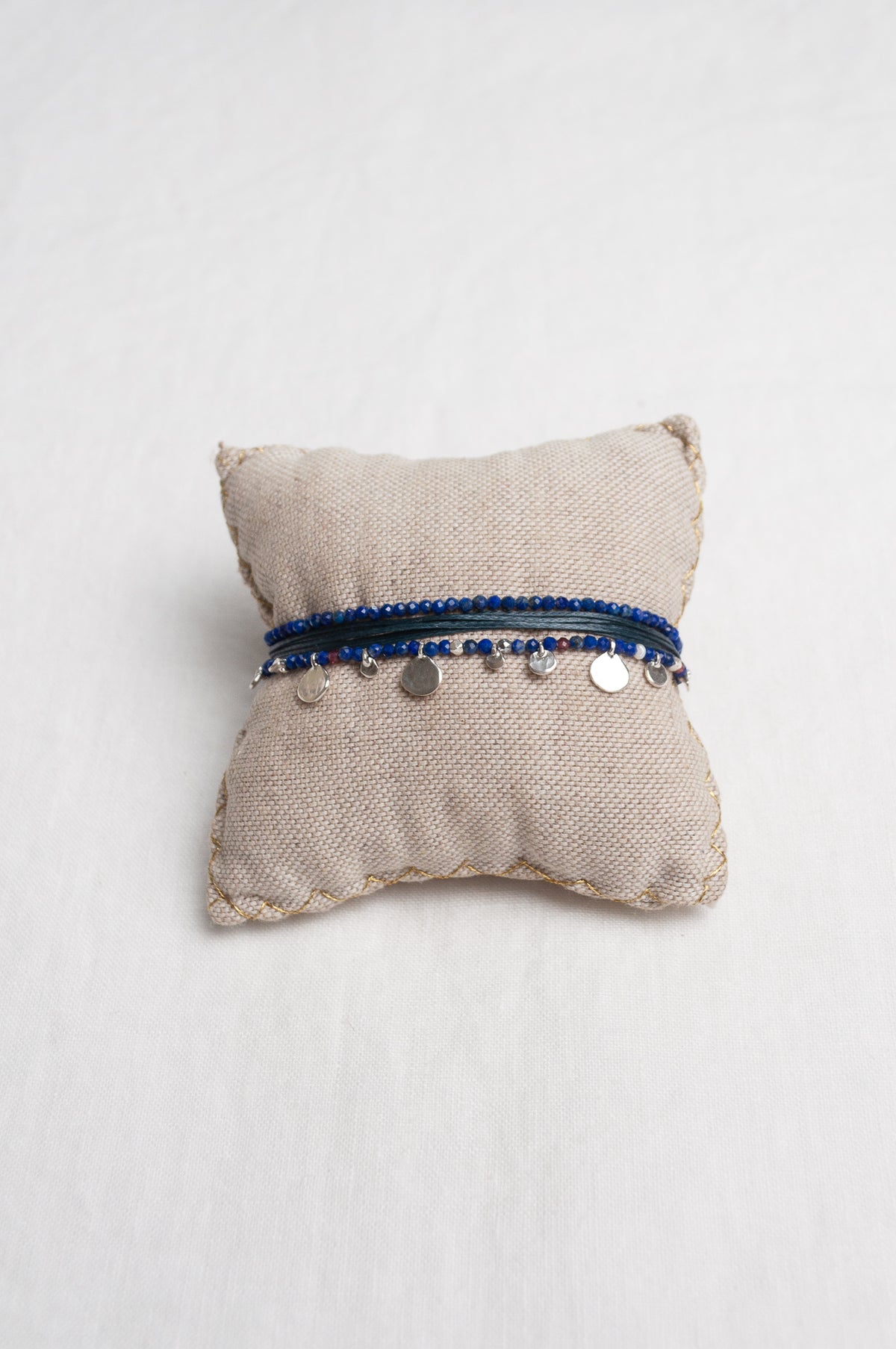 Mary Gaitani hand tooled silver charms on stranded cords with lapis beads.