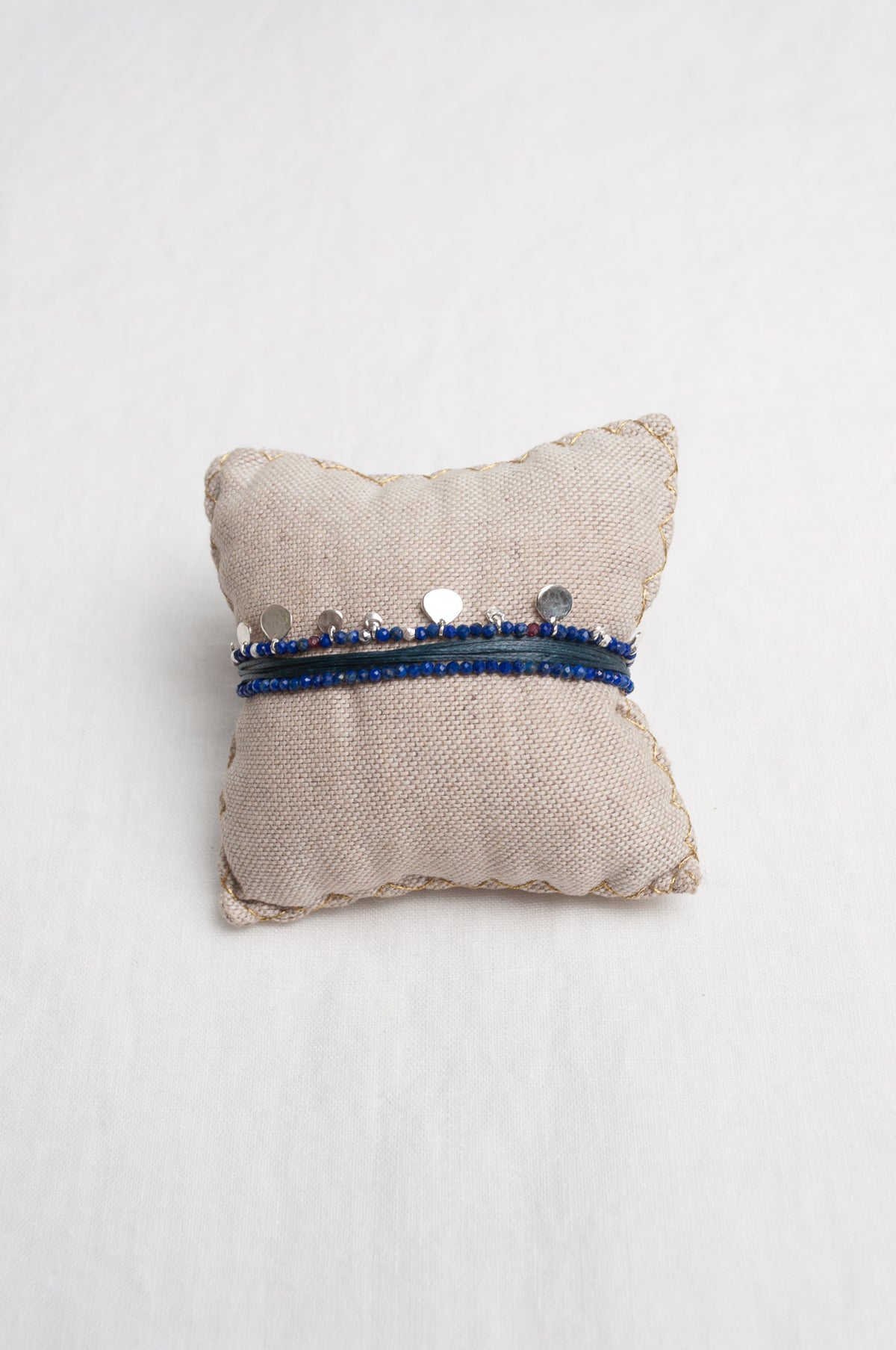 Mary Gaitani hand tooled silver charms on stranded cords with lapis beads.