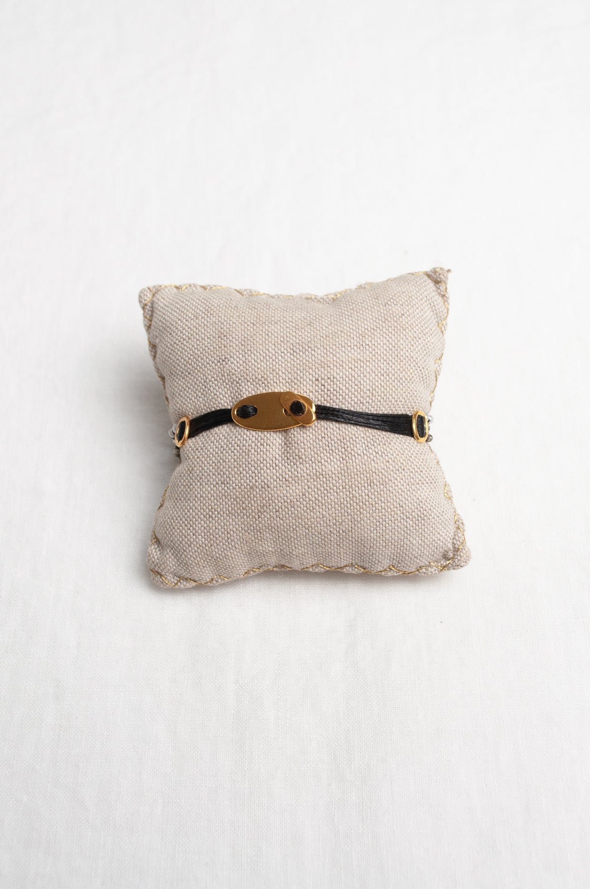 Mary Gaitani hand tooled gold charms on stranded cords with zircons and seed pearls.