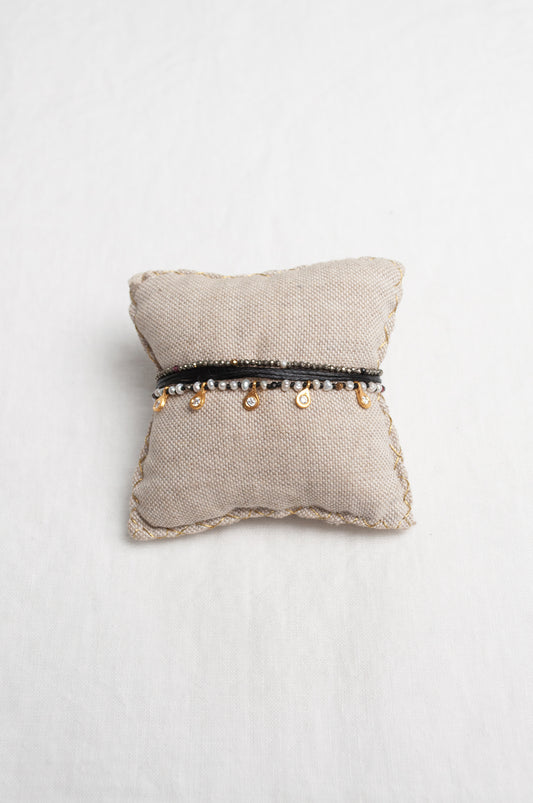 Mary Gaitani hand tooled gold charms on stranded cords with zircons and seed pearls.