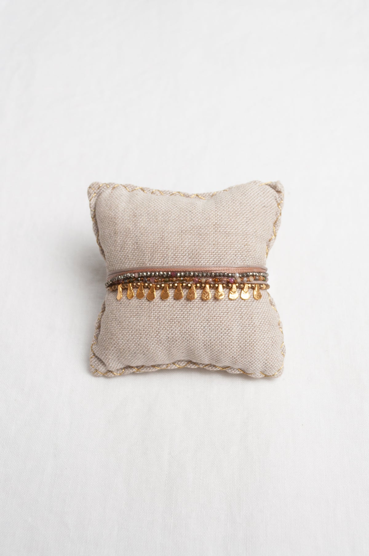 Mary Gaitani hand tooled gold teardrop charms on stranded cords with semi-precious stones.