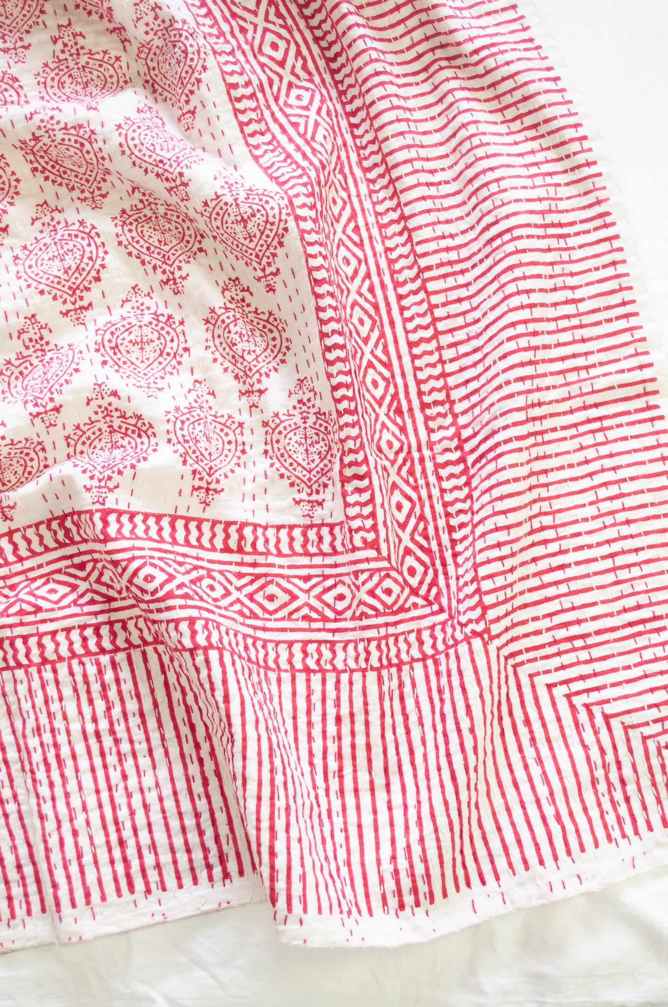 Raspberry red on white Mughal motif blockprint kantha quilt.