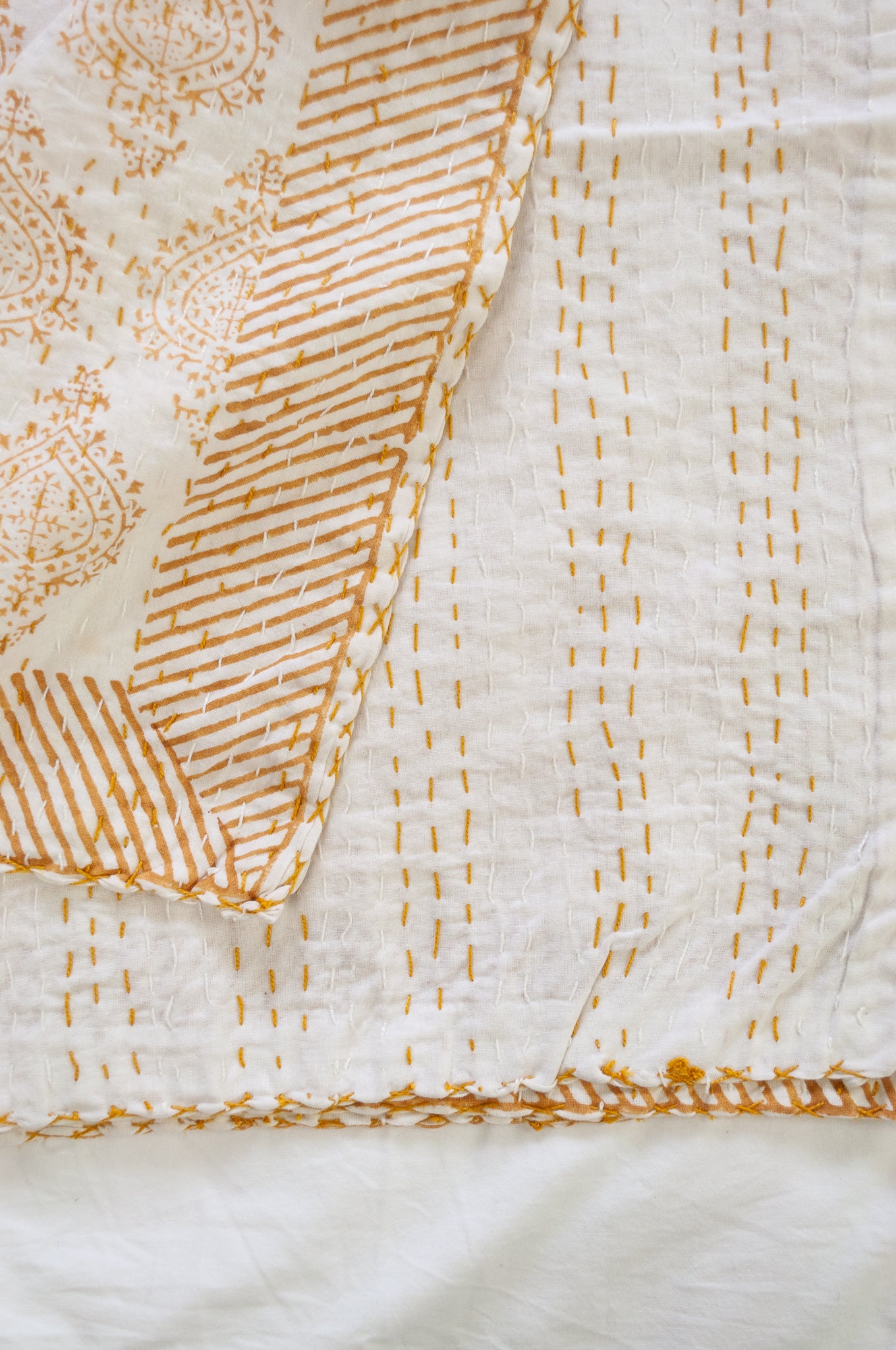 Mustard yellow on white Mughal motif blockprint kantha quilt.