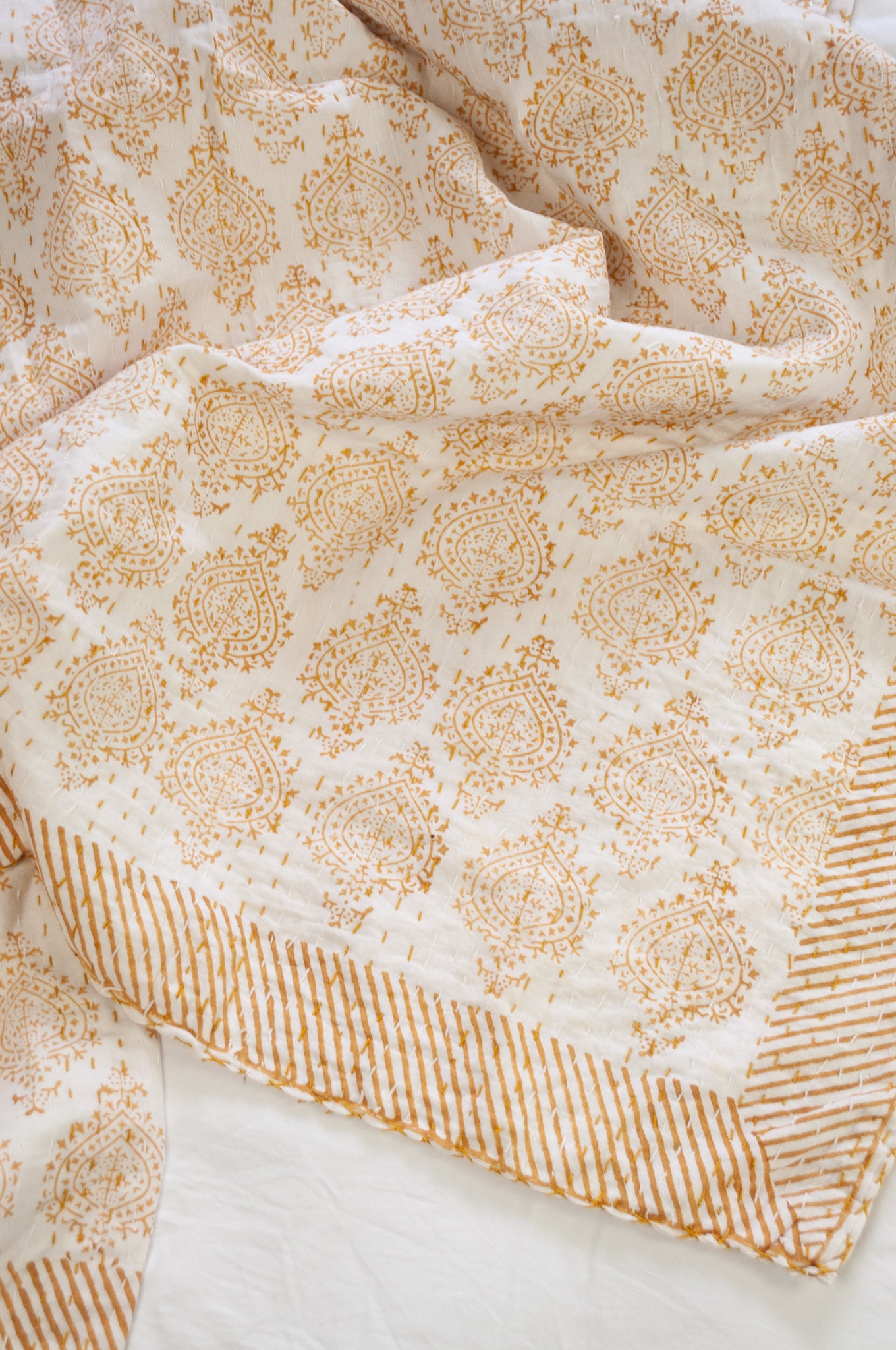 Mustard yellow on white Mughal motif blockprint kantha quilt.