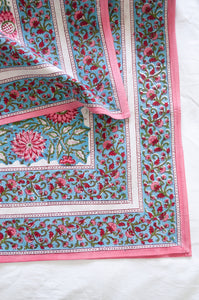 Pure cotton floral blockprint tablecloth in shades of pink on aqua blue.