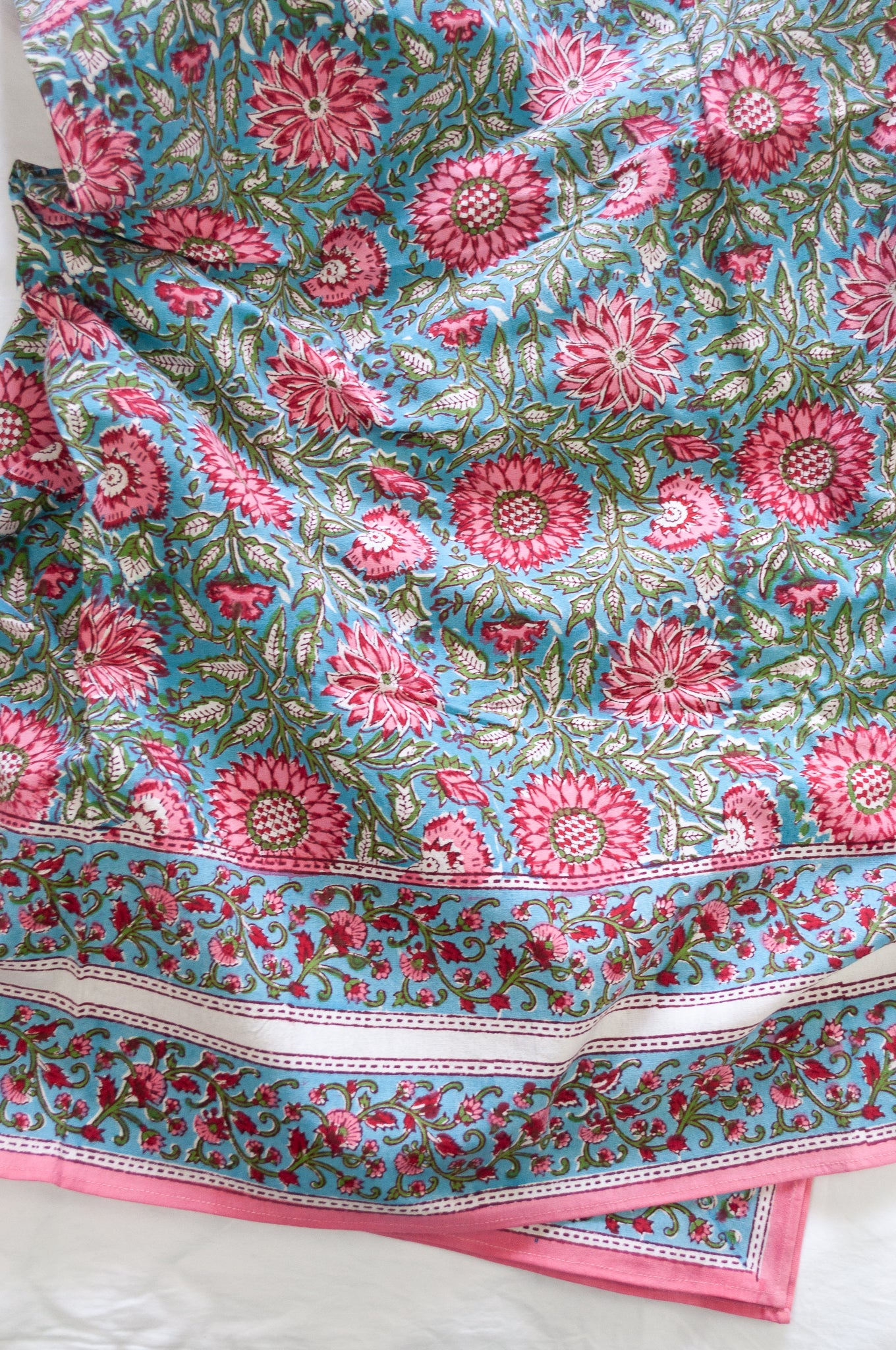 Pure cotton floral blockprint tablecloth in shades of pink on aqua blue.