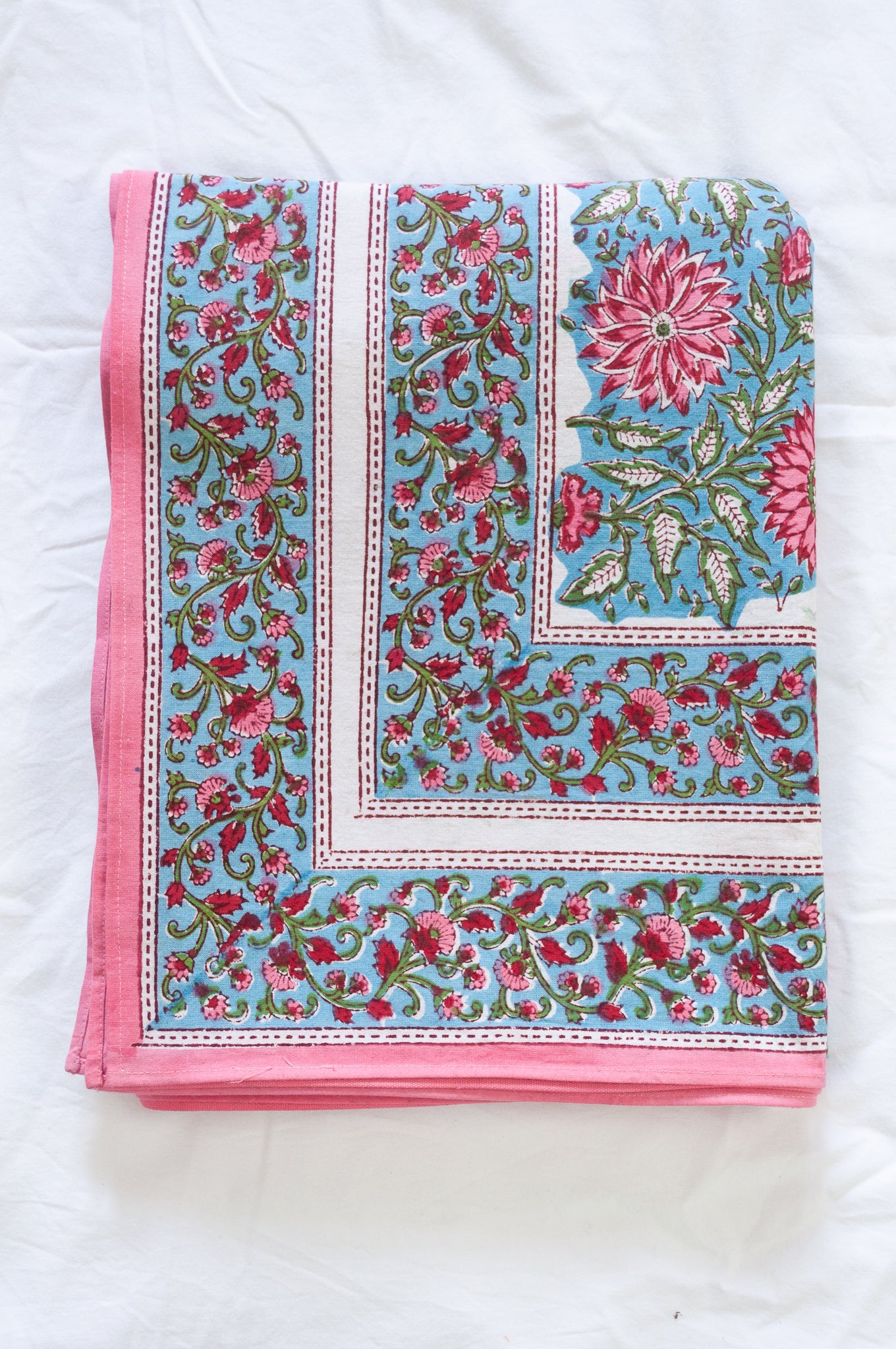 Pure cotton floral blockprint tablecloth in shades of pink on aqua blue.