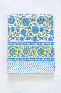 Floral blockprint cotton table cloth in shadews of aqua blue, and lime green on white.