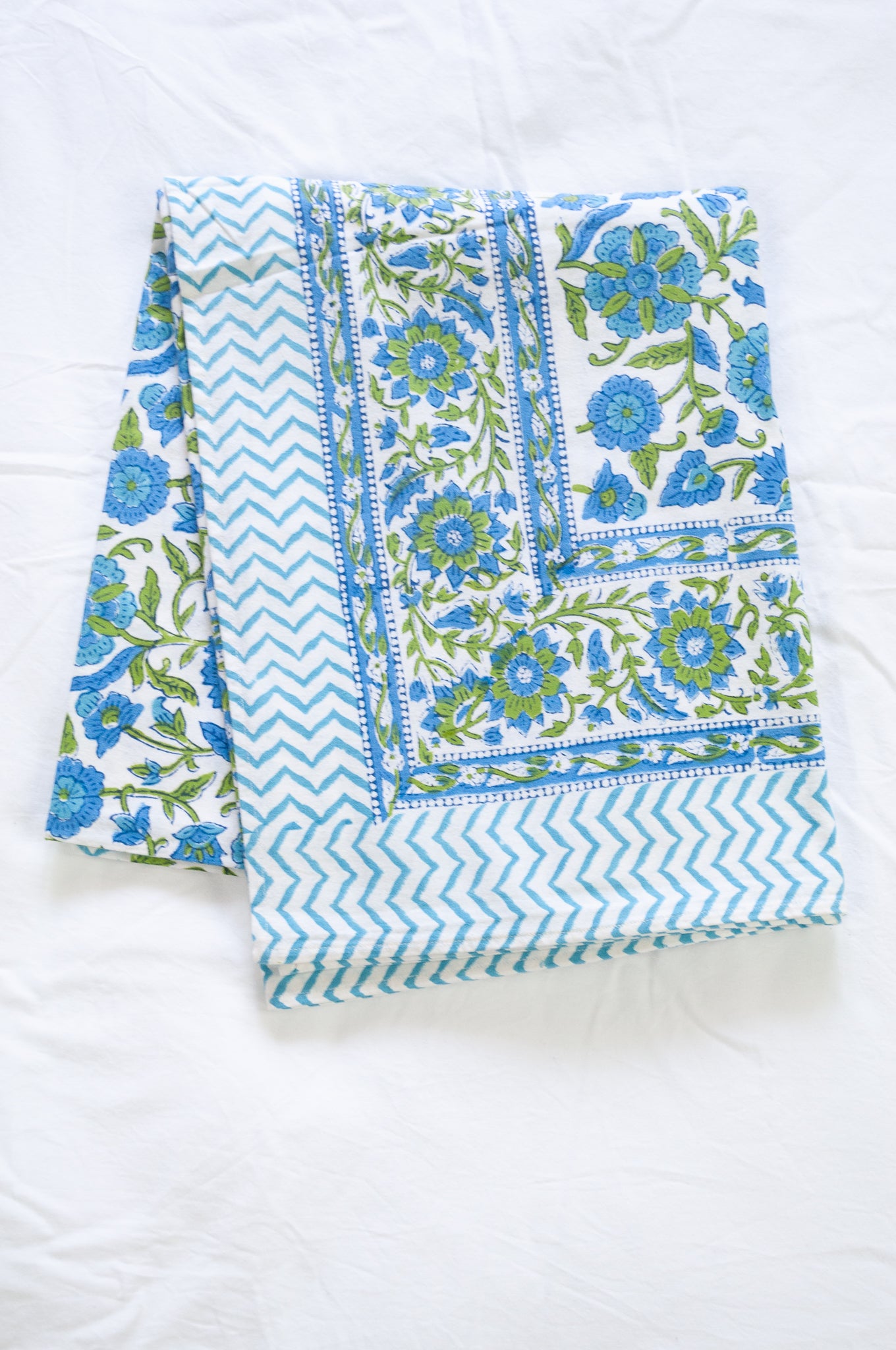 Floral blockprint cotton table cloth in shadews of aqua blue, and lime green on white.