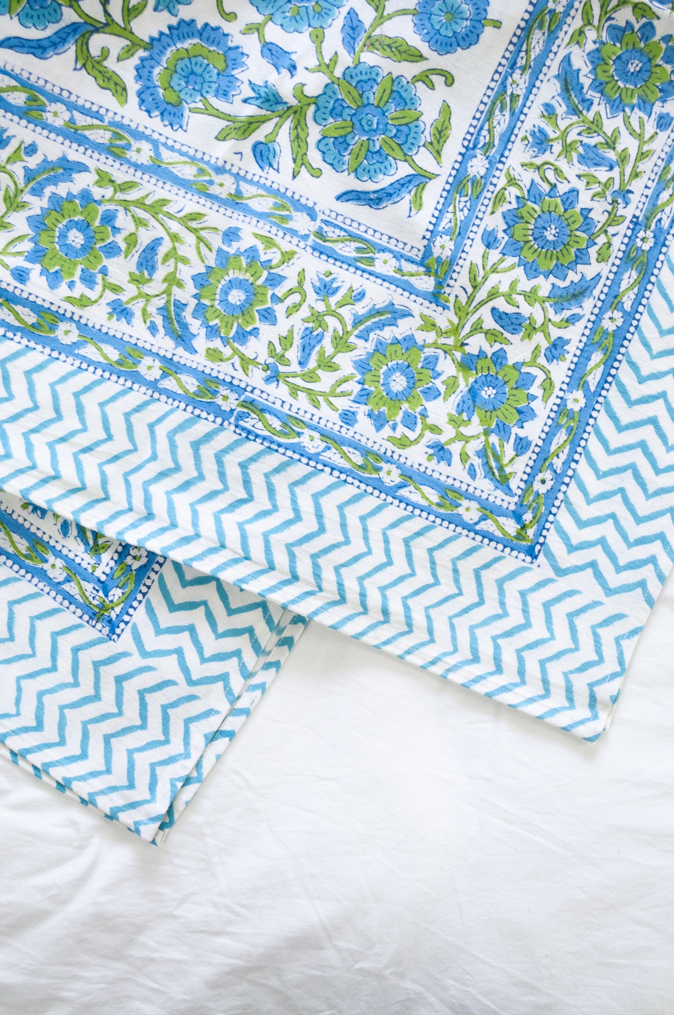 Floral blockprint cotton table cloth in shadews of aqua blue, and lime green on white.