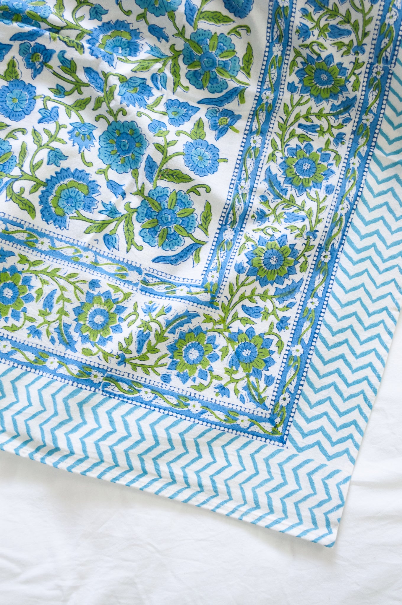 Floral blockprint cotton table cloth in shadews of aqua blue, and lime green on white.