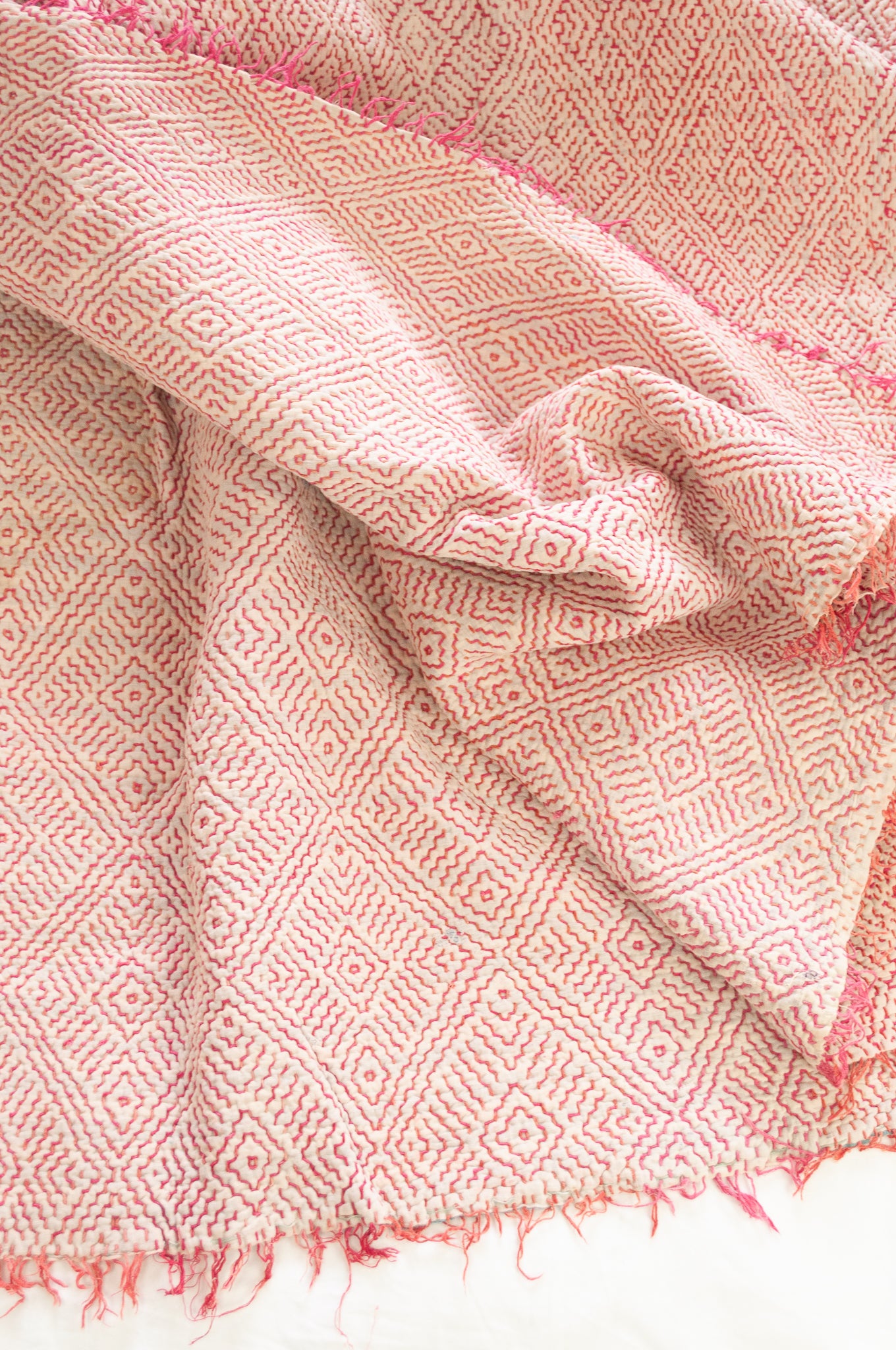 VIntage kantha quilt with  rose pink on white stitching and fringed edge.
