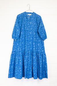 Juniper Hearth Gina dress in cornflower blue floral blockprint in organic cotton, flowy style with three quarter sleeves and deep frill skirt.