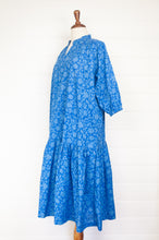 Load image into Gallery viewer, Juniper Hearth Gina dress in cornflower blue floral blockprint in organic cotton, flowy style with three quarter sleeves and deep frill skirt.