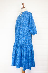 Juniper Hearth Gina dress in cornflower blue floral blockprint in organic cotton, flowy style with three quarter sleeves and deep frill skirt.