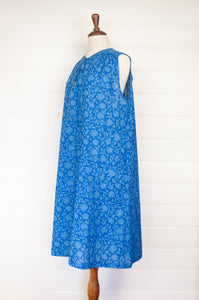 Juniper Hearth Stella dress in cornflower blue blockprint floral cotton, A-line sleeveless with front ties.