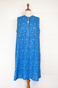 Juniper Hearth Stella dress in cornflower blue blockprint floral cotton, A-line sleeveless with front ties.