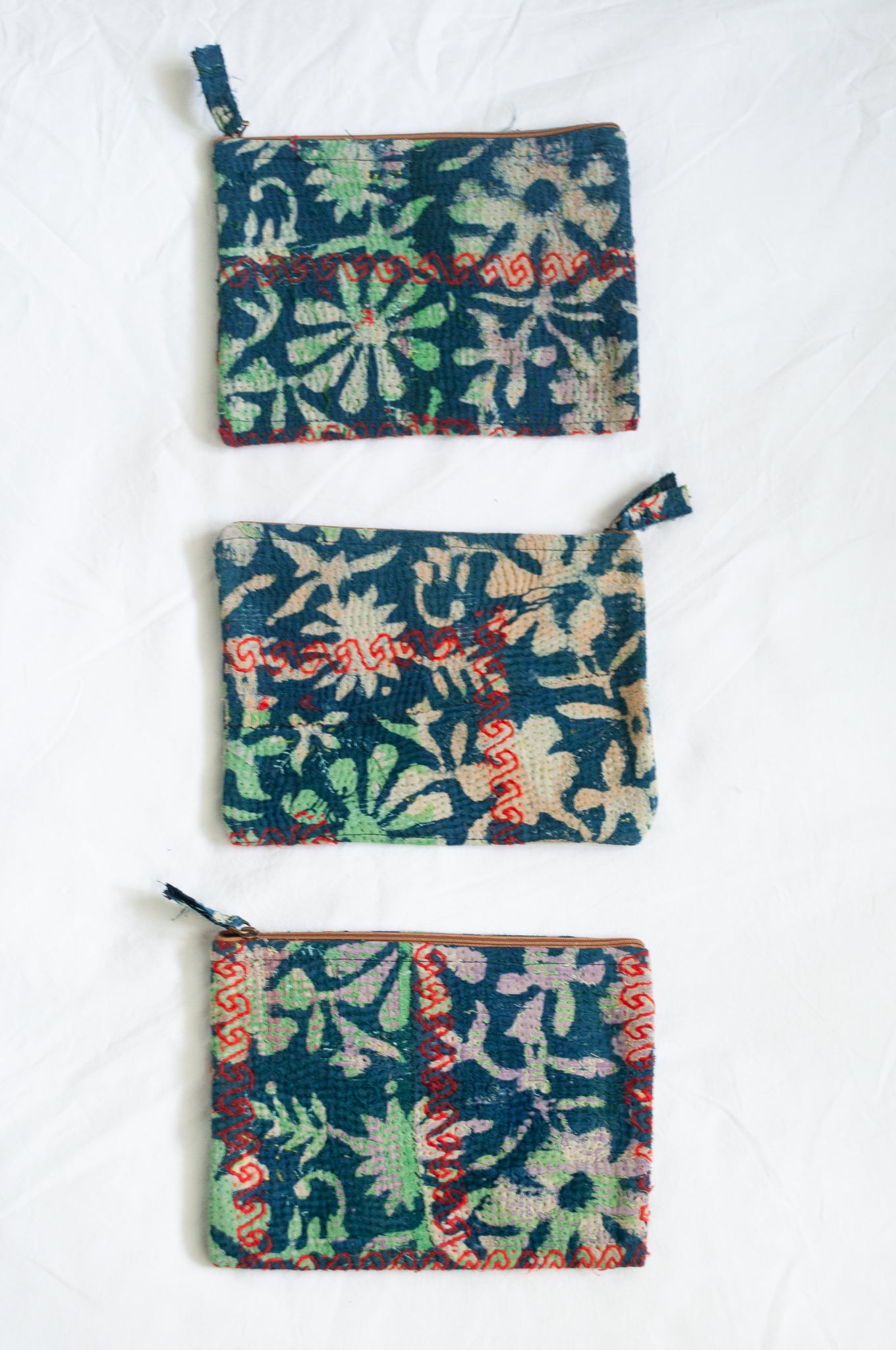VIntage kantha pouch in overdyed indigo floral design with red stitching.