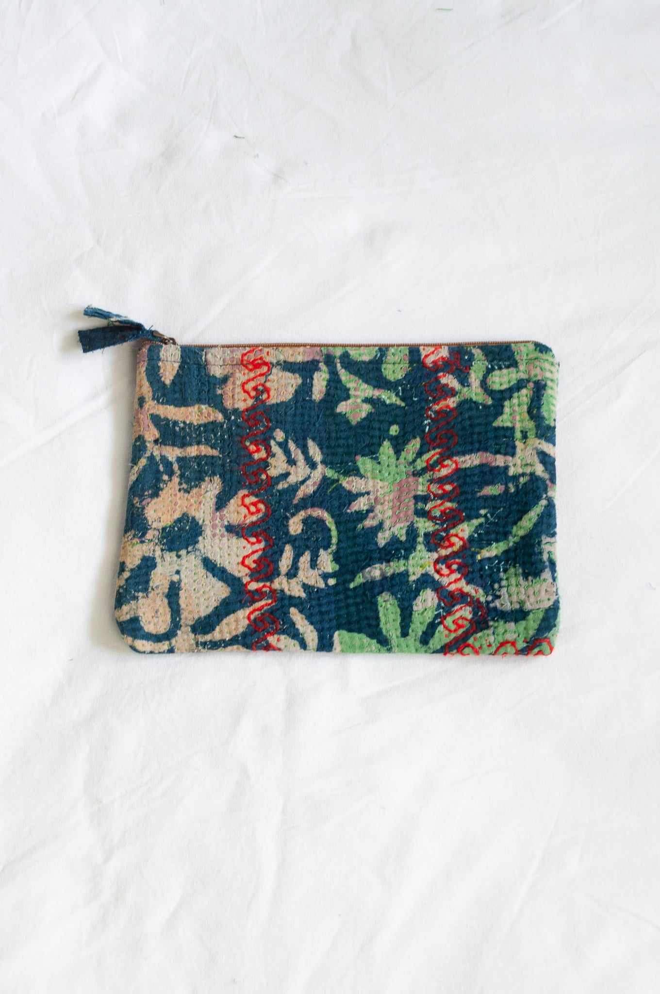 VIntage kantha pouch in overdyed indigo floral design with red stitching.