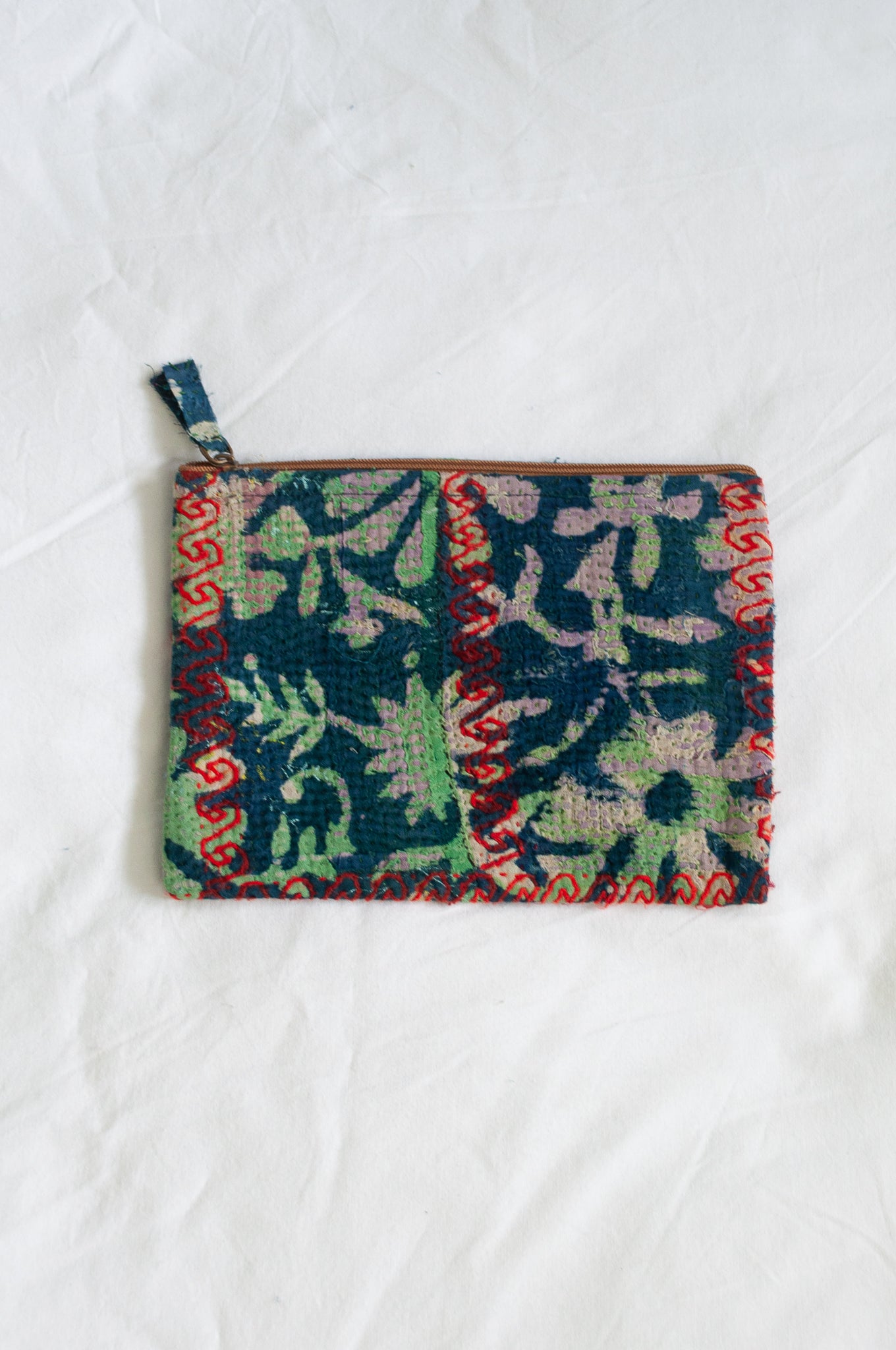 VIntage kantha pouch in overdyed indigo floral design with red stitching.