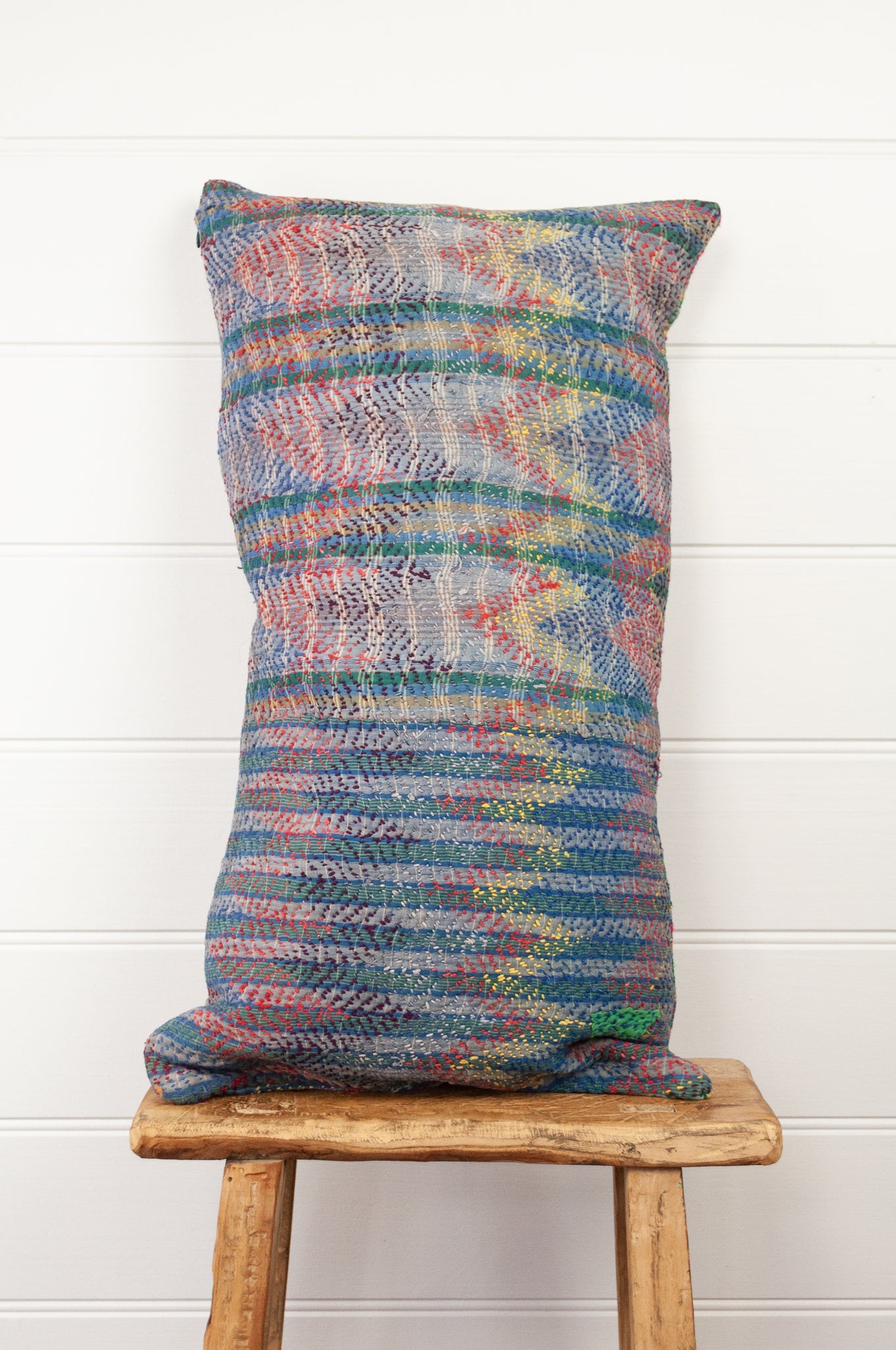 Lohori kantha stitch quilt cushion cover in multi coloured stitching on stripe background.