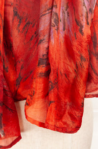 Tie dye silk scarf in shades of orange, magenta and bronze.